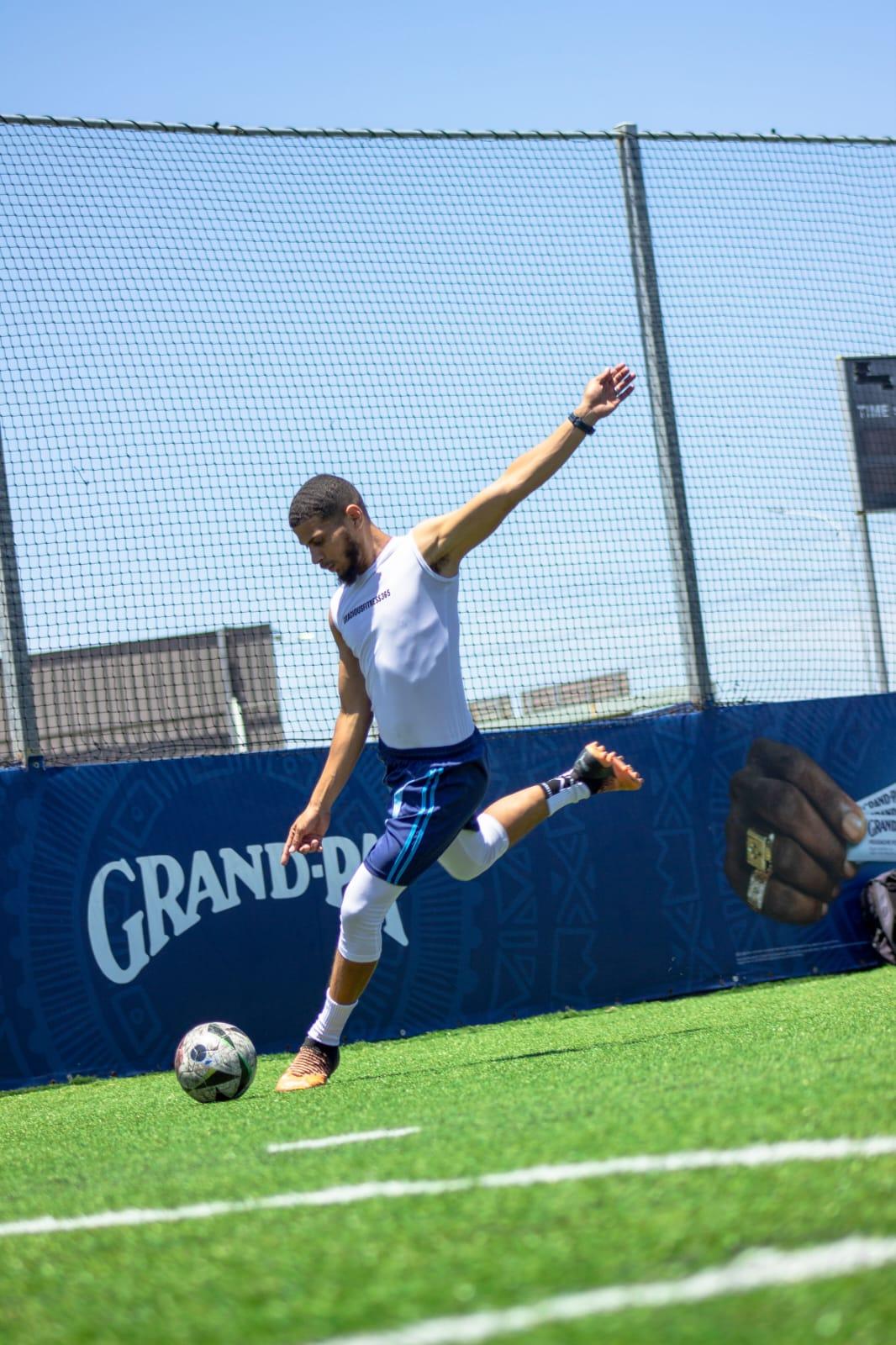 Gracious striking a football on the turf
