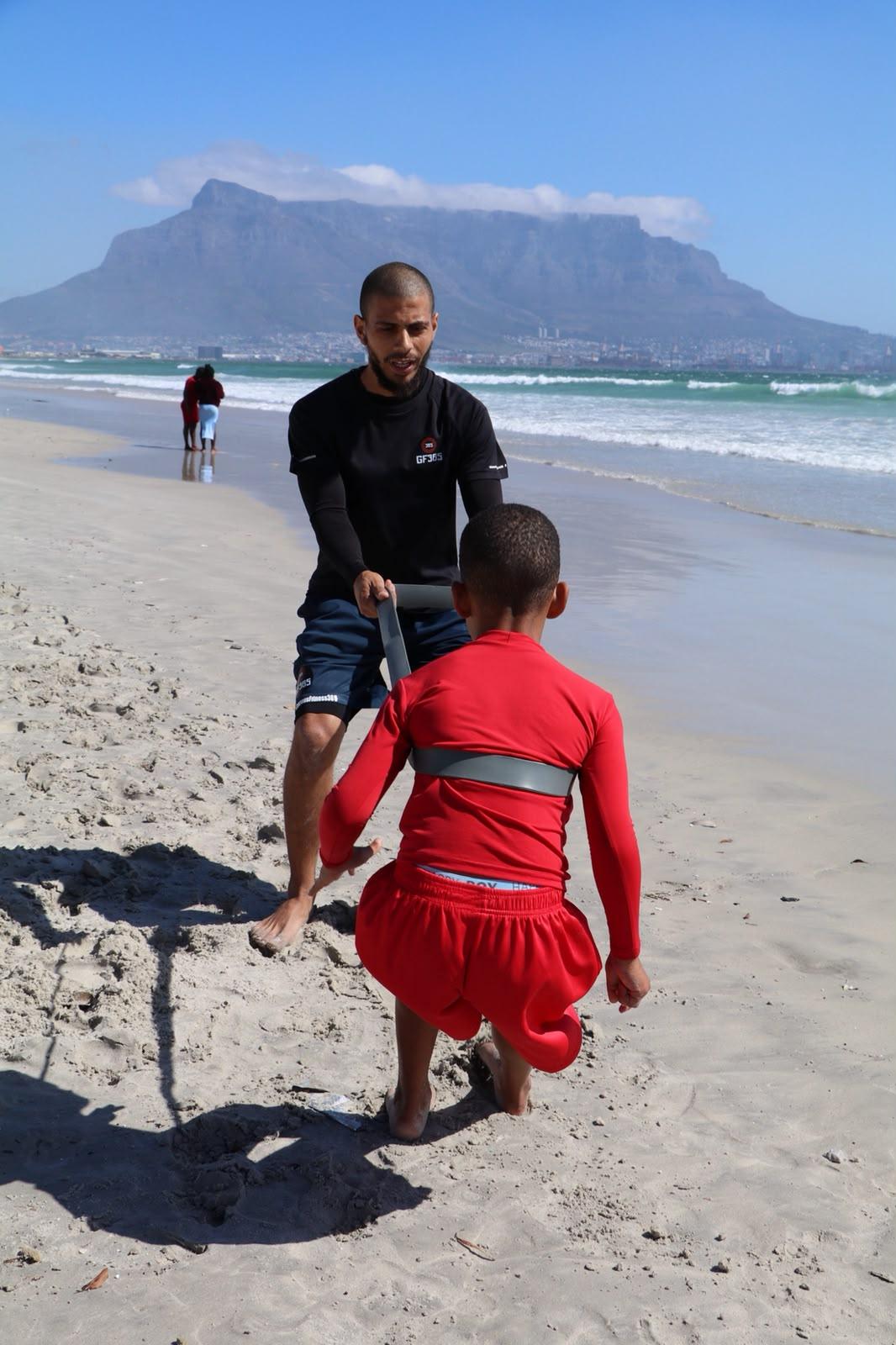 Coach guiding a resisted pull on the beach